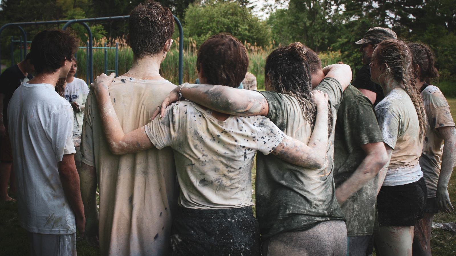 Teenagers hugging in a row, backs to the camera